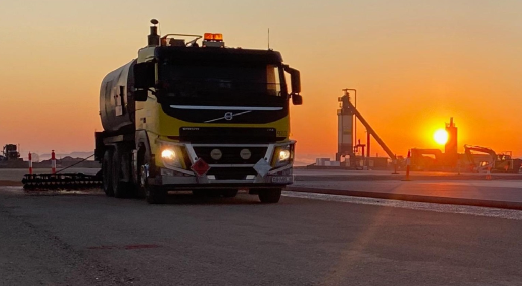 Hot Spray Seal machine on asphalt pavement with sunset in background