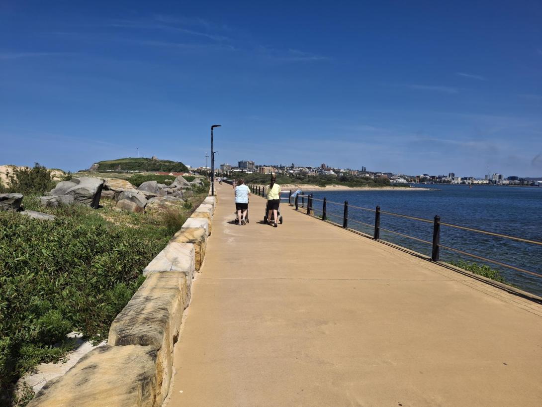 two people walking on pier with sandstone coloured concrete