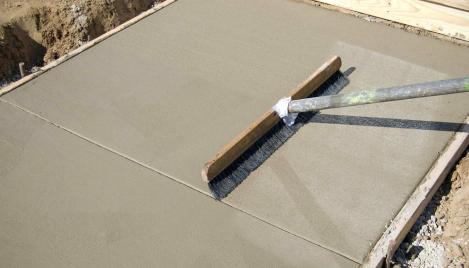 Concrete footpath being finished with a broom