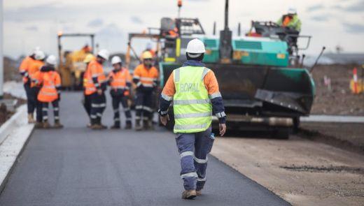 man walking towards working crew