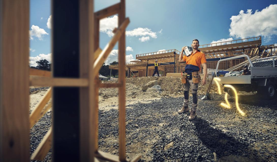 Man carrying bag of Boral packaged cement